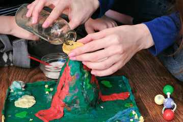 Chemical experiment. Close-up woman's hands poured water from the bottle into the funnel of the...