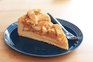 Slice of homemade vegan apple pie served on a blue plate
