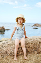 Fototapeta na wymiar Little girl in hat walking beach sunny summer day, Instagram style, fashion, Latvia, Vidzeme, Baltic Sea