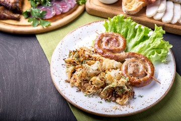 Round roast sausages on wooden skewers with fried sauerkraut. German food