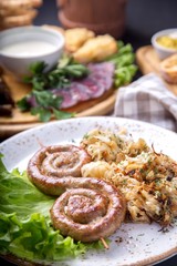 Tasty round roast sausages on wooden skewers with fried sauerkraut. German food