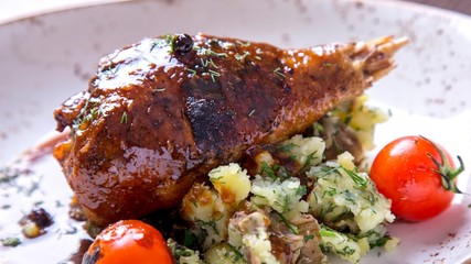 Delicious  turkey leg in sauce with garnish in a plate