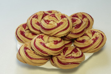 Strawberry cookies on a white dish, shortbread cookies with strawberry jam on white background...