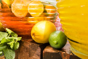 Lime, lemon and mint on the background of glass containers with lemonade. Summer drinks and cocktails.