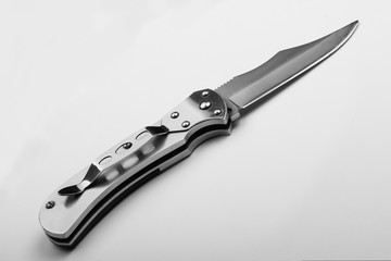 Steel folding knife with an open blade on a white background