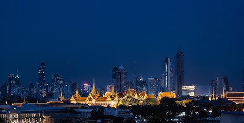Grand palace and Wat Phra Kaew surround by modern buildings, in Bangkok city Thailand