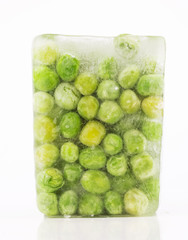 Closeup of frozen green peas in ice on white