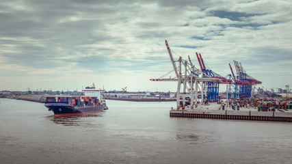 Luftaufnahme eines Container-Terminals im Hafen von Hamburg mit einem kleinen Containerschiff