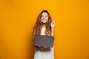 Portrait of a cheerful young girl holding laptop computer