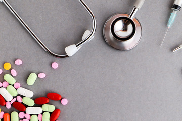 Medical equipments including stethoscope, syringe, drug medicines background, top view flat lay
