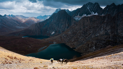 Group of horsemen with breathtaking view of Krishansar lake, Vishansar lake and big mountains under...