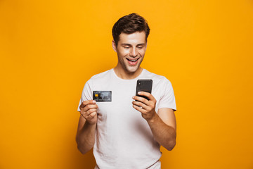 Portrait of an excited young man holding mobile phone