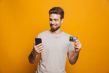 Portrait of a satisfied young man using mobile phone