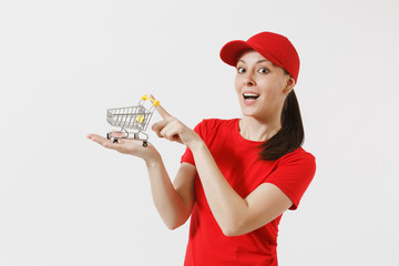 Delivery woman in red uniform isolated on white background. Female courier or dealer in cap, t-shirt, jeans holding supermarket grocery push cart for shopping on palm. Copy space for advertisement.