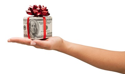 Human hand holding christmas present wrapped in dollar banknotes