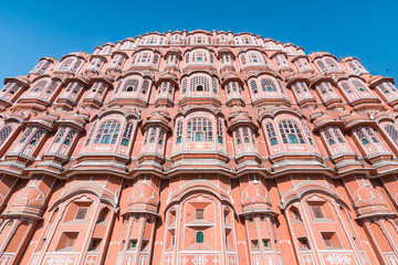 View of Hawa Mahal (Palace of Winds or Palace of the Breeze) with blue sky in background. It's constructed of red and pink sandstone, located on the edge of City Palace, Jaipur, Rajasthan, India