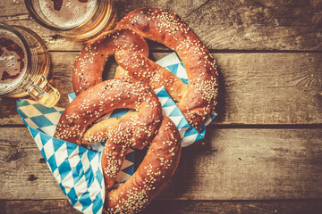 Oktoberfest concept - pretzels and beer on rustic wood background