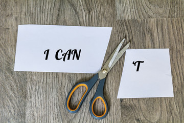 I Can Concept with Scissors Cutting  off the Letter T of the  Word I Can't. 