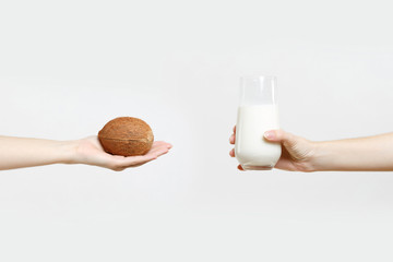 Close up female hold in hands coconut milk in glass, exotic coco nut isolated on white background. Proper nutrition, vegan vegetarian drink, healthy lifestyle, dieting concept. Copy space advertising.