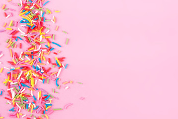 Sugar sprinkle dots hearts, decoration for cake and bakery, as a background. Isolated on pink.