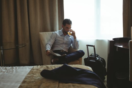 Businessman having whisky while sitting indoors