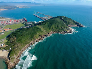  Aerial view of Brazilian beach with white sand, blue sea, and harbor.
