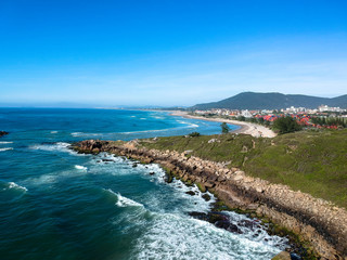  Aerial view of Brazilian beach with white sand, blue sea, and harbor.