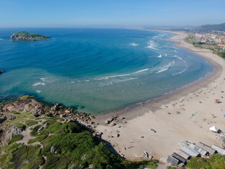  Aerial view of Brazilian beach with white sand, blue sea, and harbor.