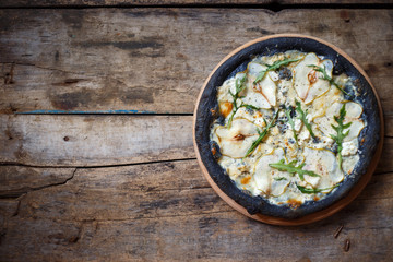 Top view black quattro formaggi pizza on wooden background with copy space. Menu, recipe or pizza delivery concept image