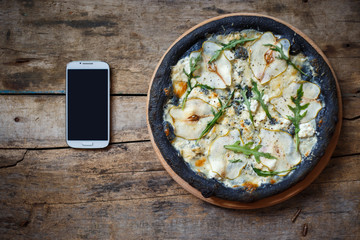 Top view black quattro formaggi pizza on wooden background with copy space. Menu, recipe or pizza delivery concept image