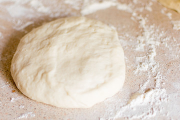 Yeast dough for pizza on the table.