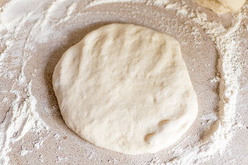 Yeast dough for pizza on the table.