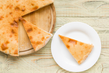 Pie with cheese, khachapuri on a wooden background.
