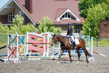 Young dressage competitor riding horse before performance. Girl warming up horse before contest