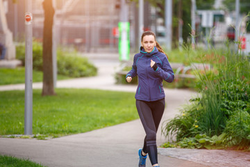 Young european woman running in the morning in city park. Healthy lifestyle background image with copy space