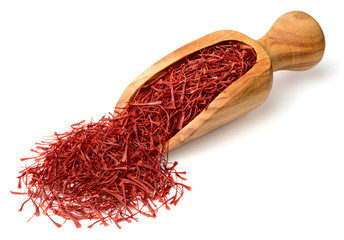 saffron thread in the wooden scoop, isolated on the white background.