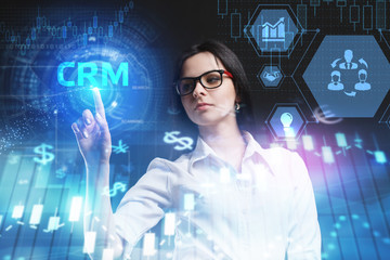 The concept of business, technology, the Internet and the network. A young entrepreneur working on a virtual screen of the future and sees the inscription: CRM