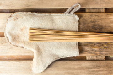 Bamboo broom lies on a white mitten in a bath
