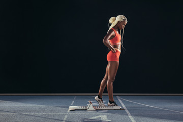 Woman runner standing on a running track