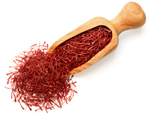 saffron thread in the wooden scoop, isolated on the white background, top view.