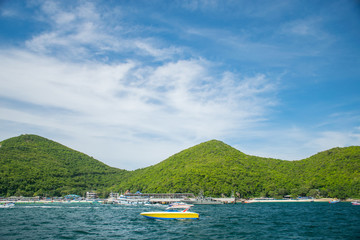 Speed boat in the sea at Koh Lan Island with mountain and sky background