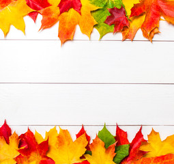 Naklejka na ściany i meble Autumn frame with colorful marple leaves on white wood background with Copy space. Flat lay, top view.