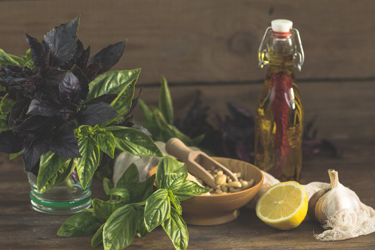 Many food ingredients for making pesto on dark wooden background