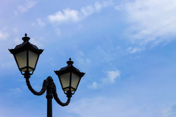 Fototapeta na wymiar City lights in a public park against a blue sky