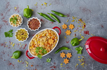 Basmati rice pilaf with chickpeas, carrots and vegetables. Ingredients pepper, spices and spices on grey background