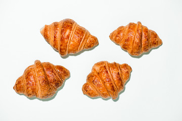 Breakfast with fresh tasty croissants on green background