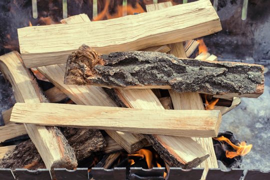 Firewood is burning in the grill in the open air