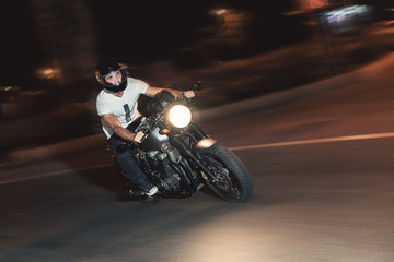 Fototapeta na wymiar The biker is riding a motorcycle on the highway at night. Speed.