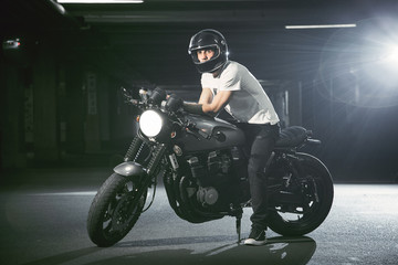  A portrait of a biker on a motorcycle in a parking lot.