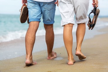 Fototapeta na wymiar Closeup of a Couple Walking on the Beach